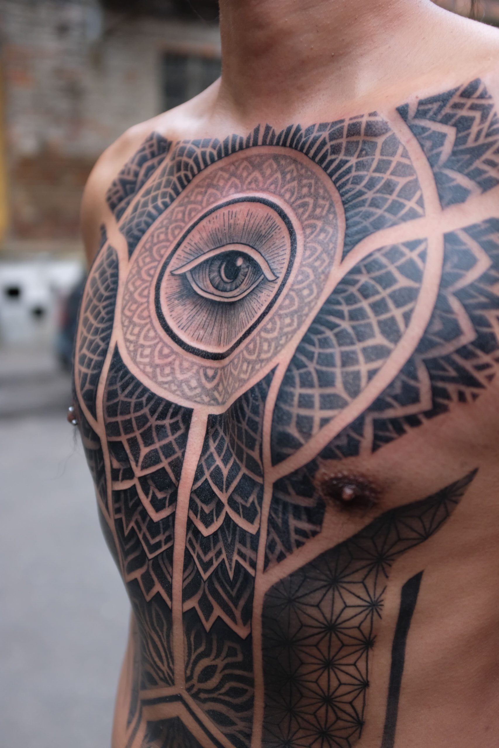 black ornamental eye tattoo on the chest