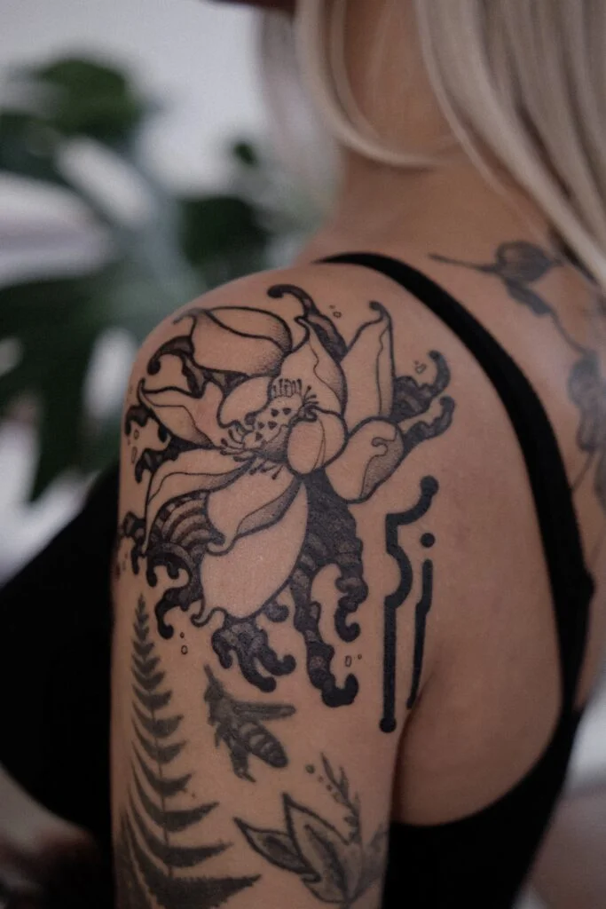 black japanese flower tattoo on girl's hand